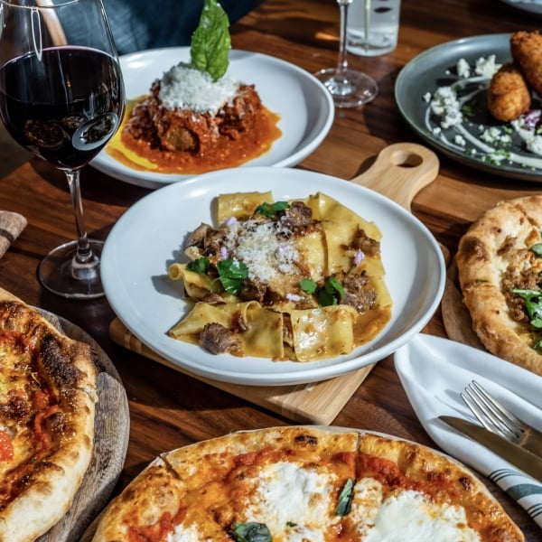 Pizza and pasta on table in Giulia