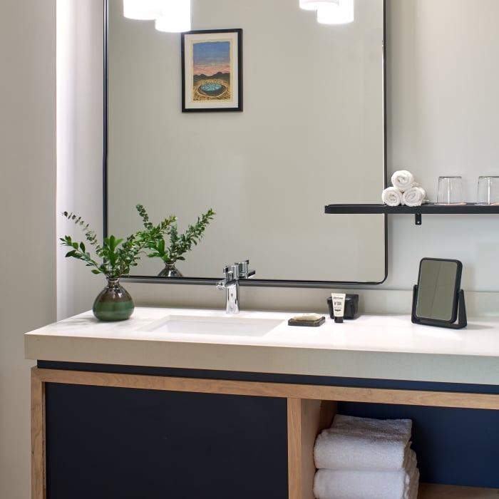 A marble bathroom sink with a large mirror