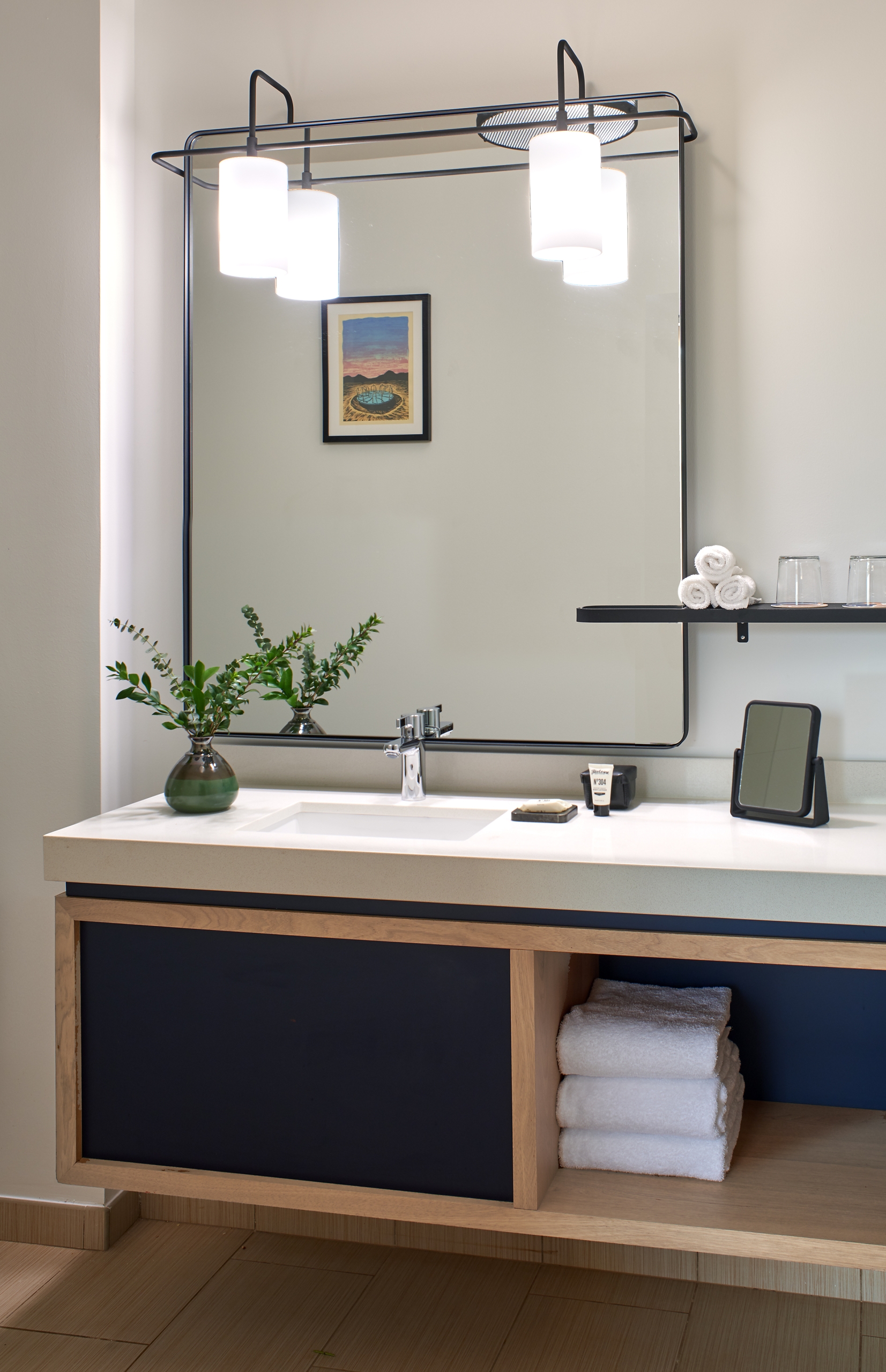 A marble bathroom sink with a large mirror