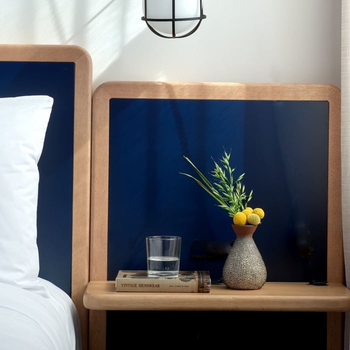 A soft bed with a navy headboard