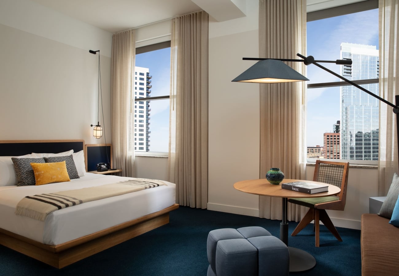 A spacious bedroom with a table and chairs.