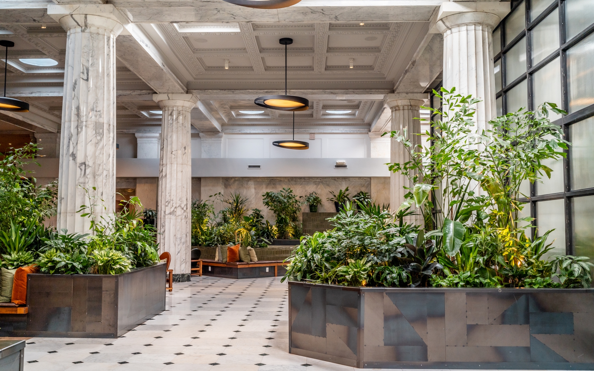 The lobby of Hotel Emery, with marble columns and plants