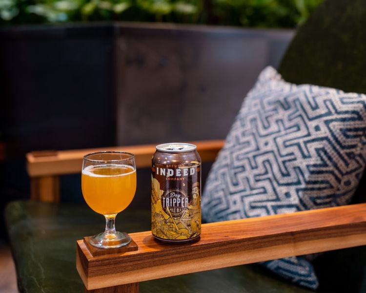 A glass of beer on the arm of a chair