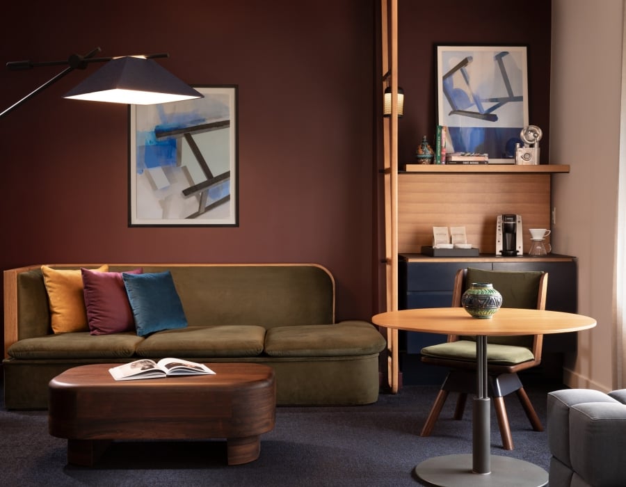 A green couch in a room with wooden furniture