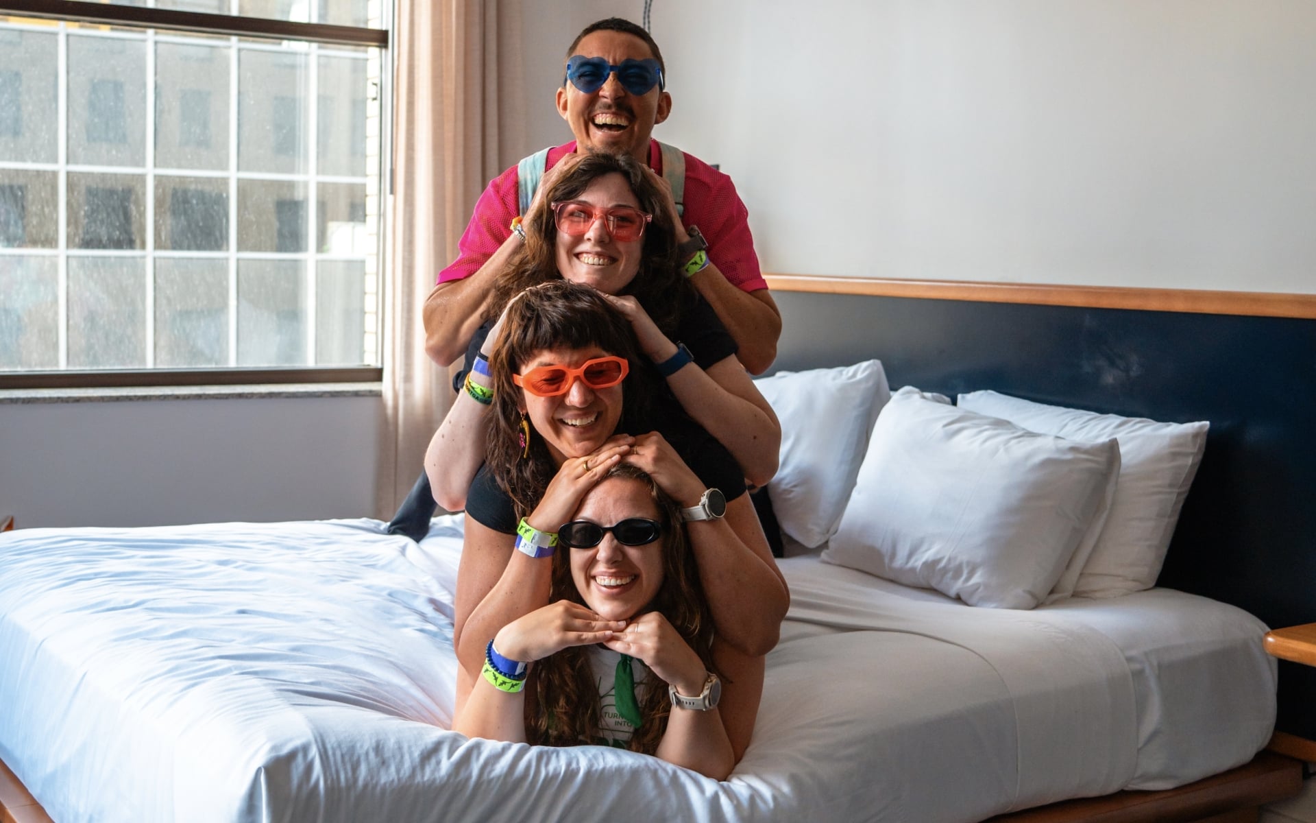 Four friends laying on bed