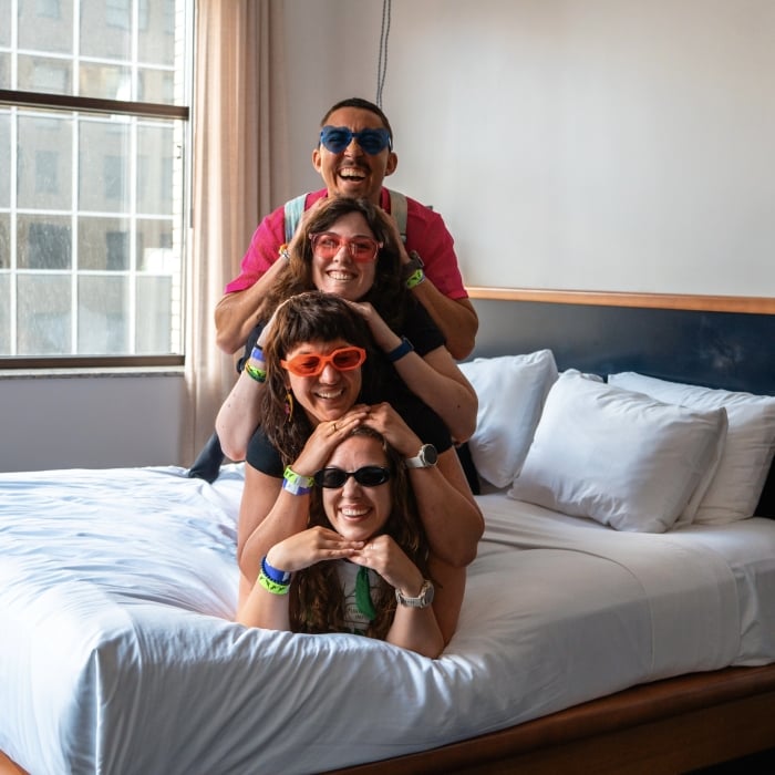 Four friends laying on bed