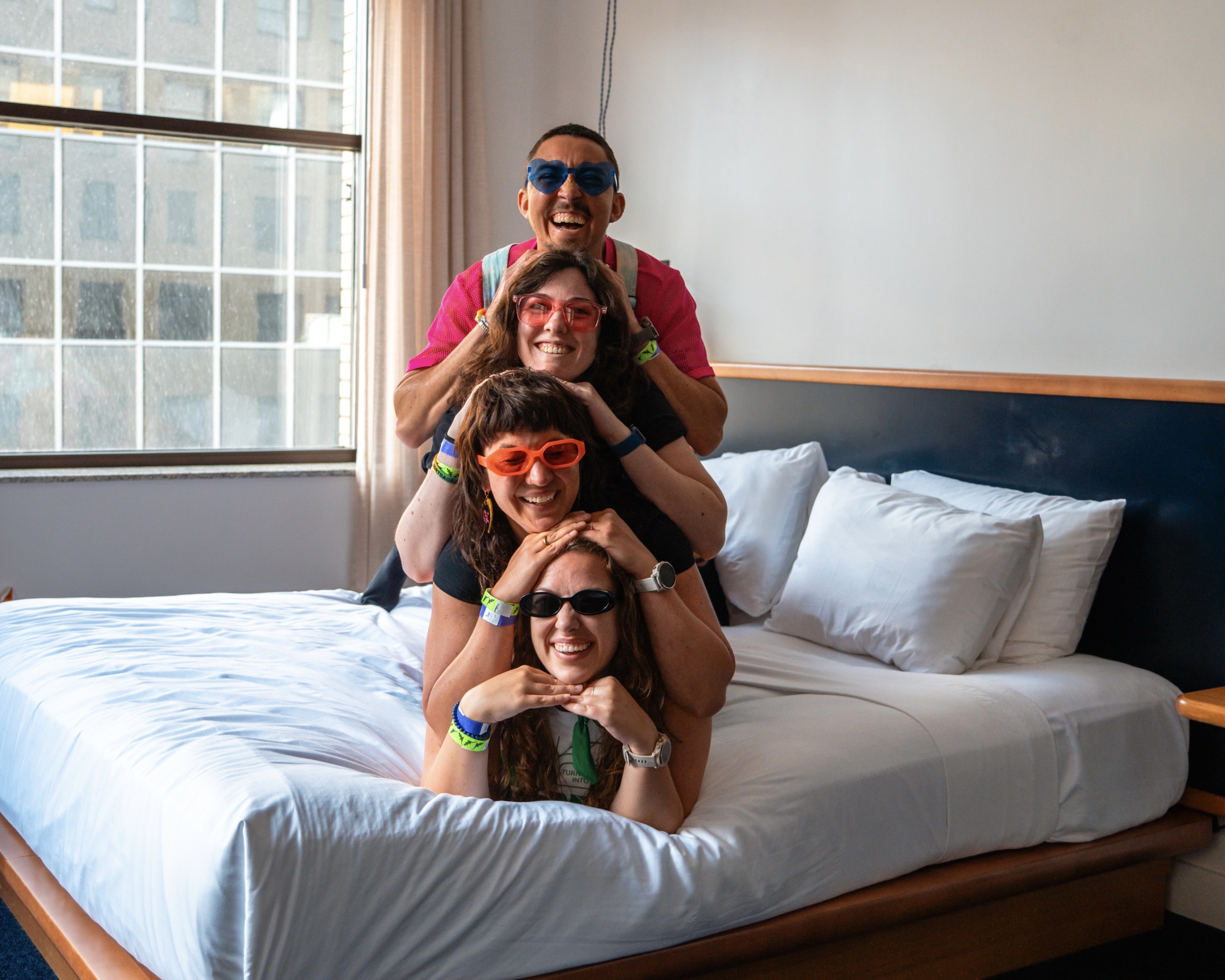 Four friends laying on bed