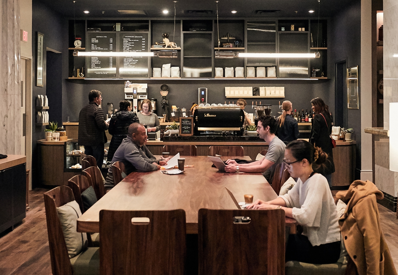 Busy community table with people at coffee shop